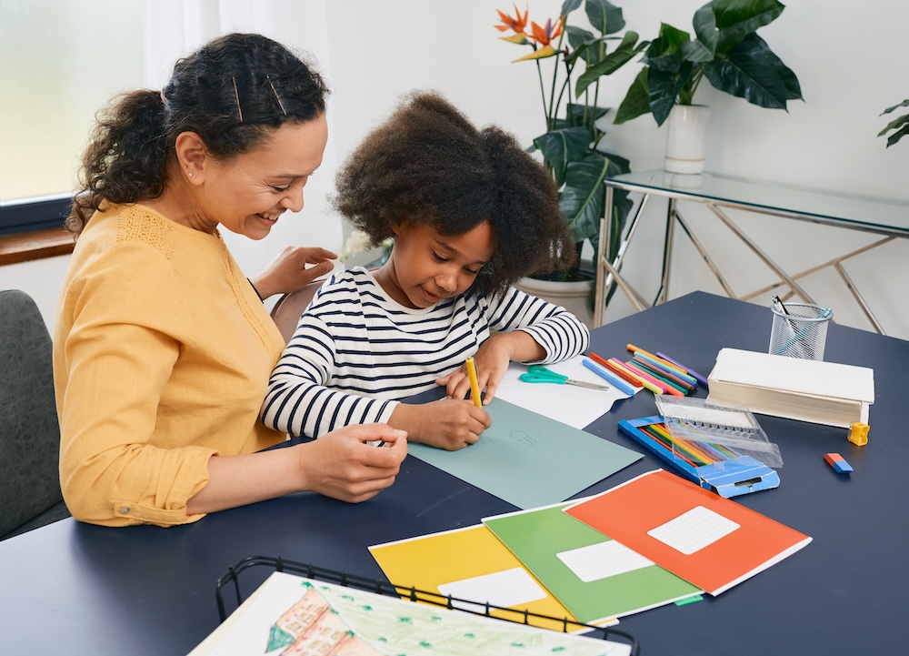 Child at desk with teacher learning